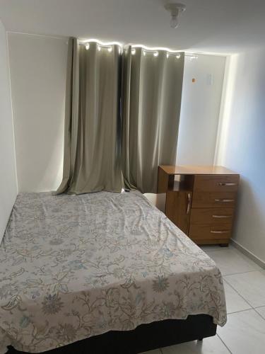 a bedroom with a bed and a wooden dresser at Apartamento em João Pessoa in João Pessoa