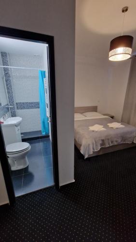 a bathroom with a bed and a toilet in a room at Casa Soficu in Iaşi