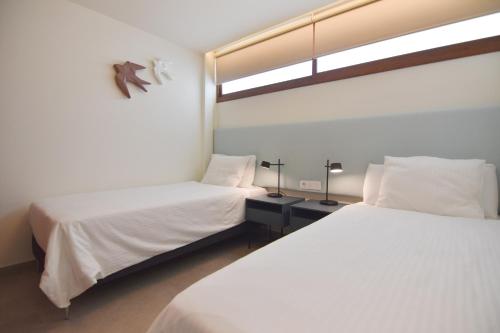 a bedroom with two beds and a window at Cisne 32 in Playa del Ingles