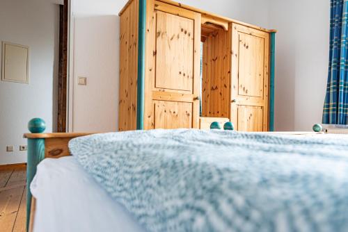 a bedroom with a bed and wooden cabinets at Haus Silko - FeWo in top Lage - 3 min zum Strand direkt am Kurpark in Warnemünde