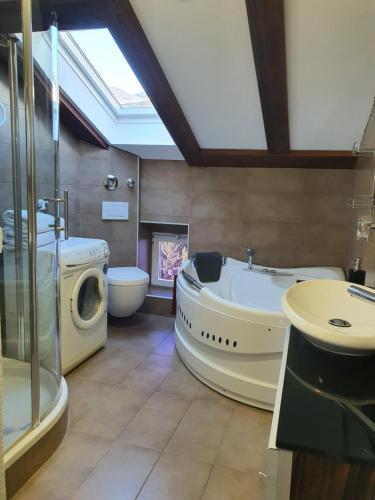 La grande salle de bains est pourvue d'une baignoire et d'un lave-linge. dans l'établissement Central Opatija 3 bedroom apartment Mozart, à Opatija