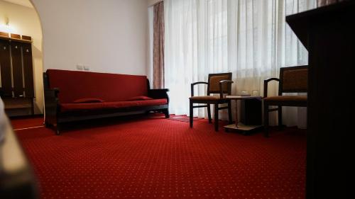 a living room with a red couch and chairs at Vila Trandafirul si Liliacul in Căciulata