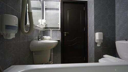a bathroom with a sink and a toilet and a tub at Vila Trandafirul si Liliacul in Căciulata