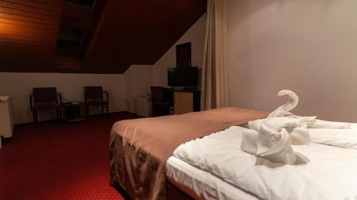 a hotel room with a bed with towels on it at Vila Trandafirul si Liliacul in Căciulata
