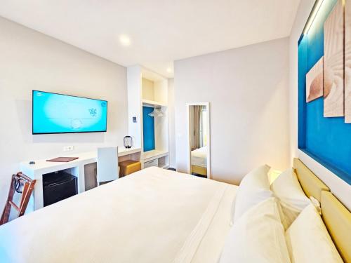 a bedroom with a bed and a desk and a tv at Hotel l'Approdo in Porto Azzurro