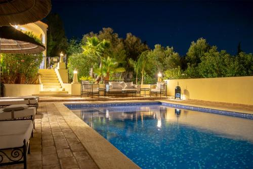 a swimming pool in a backyard at night at Casa Lusitania 19 in Faro