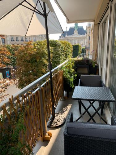 patio con mesa y sombrilla en el balcón en L'ELEGANCE SOUS LE SOLEIL, en Levallois-Perret
