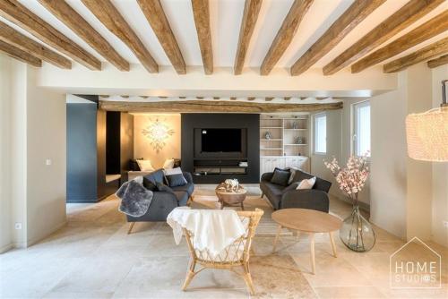 a living room with couches and a tv at La demeure des Saga - Luxe et foret in Arbonne-la-Foret