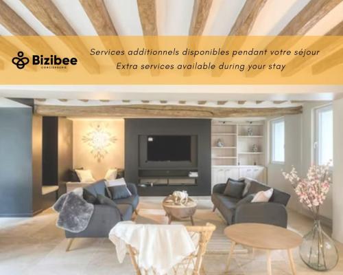 a living room with a couch and a tv at La demeure des Saga - Luxe et foret in Arbonne-la-Foret