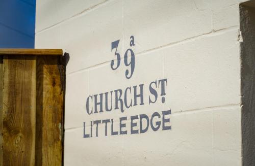 a sign on the side of a building that reads a churchessittle intelligence at Little Edge: Bright and Modern Central Apartment in Berwick-Upon-Tweed