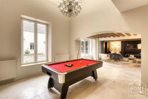 - un salon avec un billard rouge dans l'établissement La demeure des Saga - Luxe et foret, à Arbonne