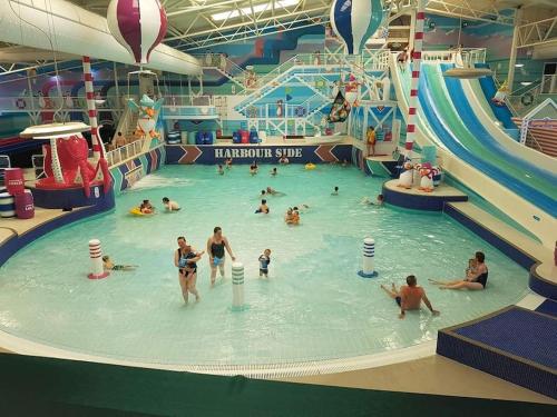 a group of people in an indoor swimming pool at Snowdonia View@puffin Lodges in Chwilog