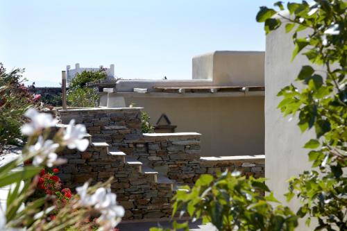 a stone staircase on a house with flowers at Diles & Rinies in Tinos Town