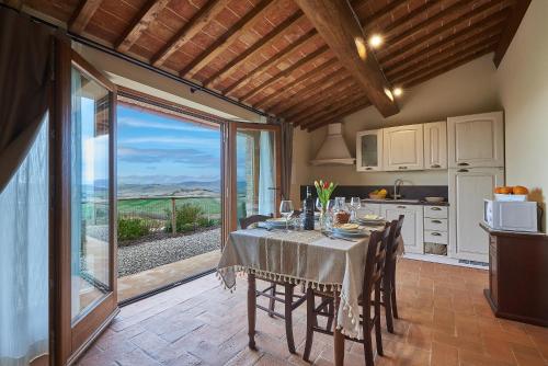 a kitchen and dining room with a table with a view at Agriturismo Bonello in Pienza