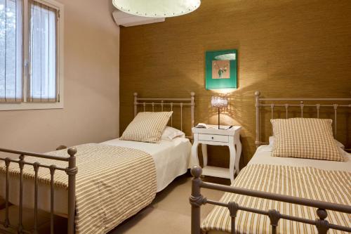 a bedroom with two beds and a table with a lamp at Diles & Rinies in Tinos Town