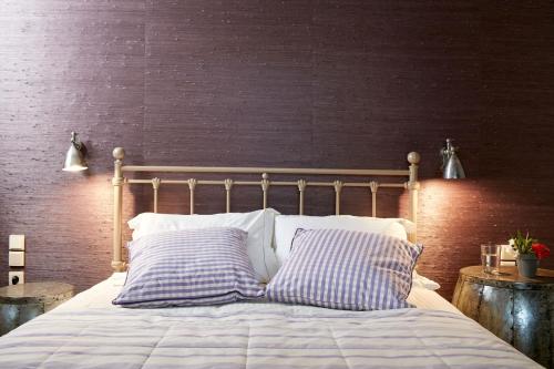 a bed with two pillows on it in a bedroom at Diles & Rinies in Tinos Town