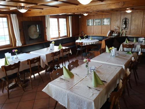 ein Esszimmer mit weißen Tischen und Stühlen sowie grünen Servietten in der Unterkunft Hotel DreiKönig & Restaurant SeeGourmet in Hagnau