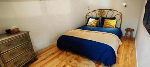 a bedroom with a bed with blue sheets and yellow pillows at Maison avec hammam privé en option - Maison Mandala in Legé