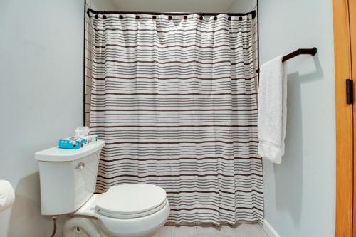 a bathroom with a white toilet and a shower curtain at Fourth Sisters Escape in Sisters