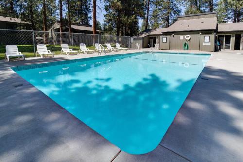 a large blue swimming pool with chairs around it at Fourth Sisters Escape in Sisters