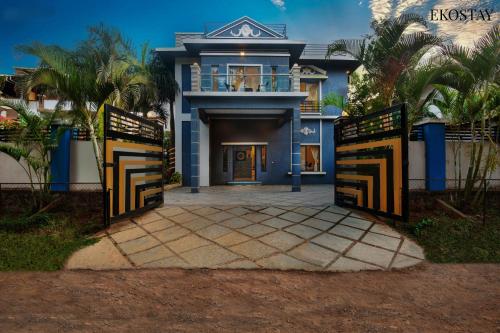 a blue house with a gate and a driveway at EKO STAY (Gold) - BLUE PEBBLE VILLA in Lonavala