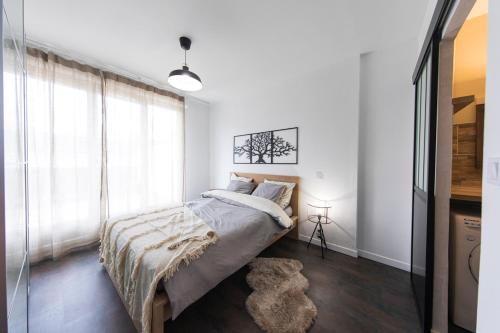 a bedroom with a bed and a large window at Appartement grande terrasse proche de Tours centre in Tours