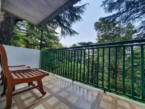 a porch with a bench on a balcony at The Cocoon Project in McLeod Ganj