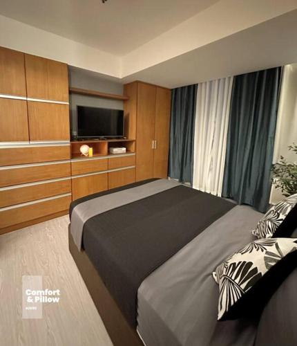 um quarto com uma cama e uma televisão de ecrã plano em Azure urban resort modern condo em Manila
