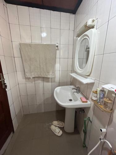 een kleine badkamer met een wastafel en een spiegel bij Villa Soto in Conakry