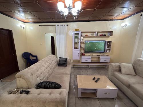 a living room with a couch and a tv at Villa Soto in Conakry