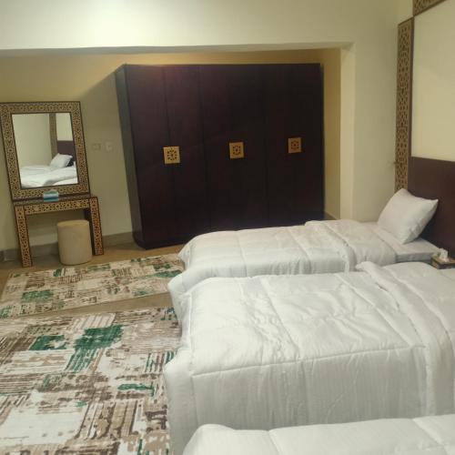 a hotel room with two beds and a mirror at Sooly pyramids Inn in Cairo