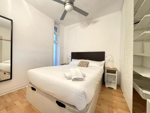 加瓦的住宿－Panoramic view Gavà Mar，卧室配有一张白色大床和吊扇