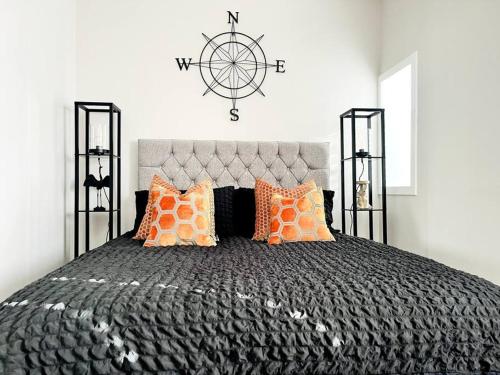 a bedroom with a large bed with a clock on the wall at Inverkar Mews Cottage, Ayr in Ayr