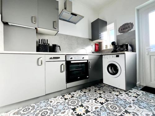 a kitchen with a washer and dryer on a tile floor at Inverkar Mews Cottage, Ayr - SA-00520-F in Ayr