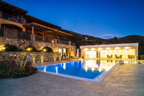 a swimming pool in front of a house at Cilento Holiday Village in Montecorice
