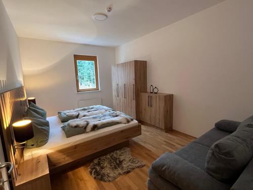 a bedroom with a bed and a couch at Foxi apartment, Pohorje in Hočko Pohorje