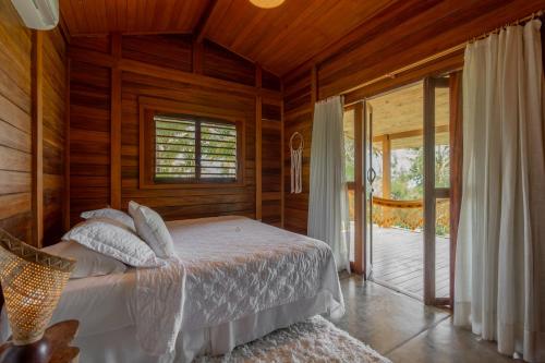 a bedroom with a bed in a wooden room at Villa Mango in Icaraí