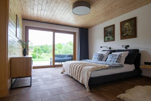 a bedroom with a bed and a large window at ChataLaba in Wetlina