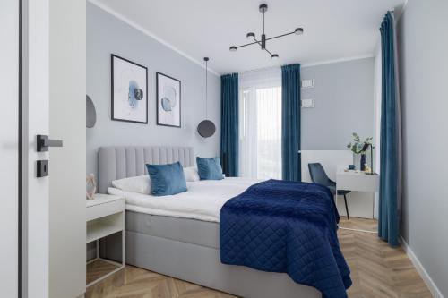 a bedroom with a bed with a blue blanket at Unique Apartment with Balcony & Parking Zabłocie Cracow by Renters Prestige in Krakow