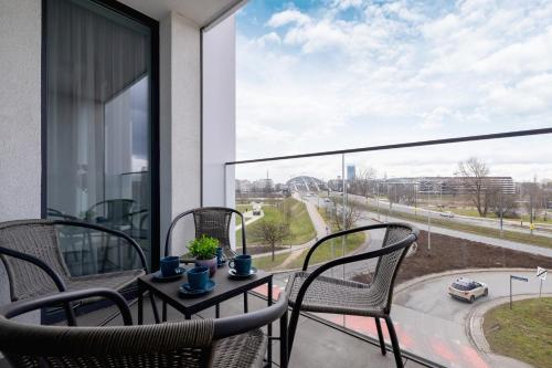 a balcony with chairs and a table with a view of a street at Unique Apartment with Balcony & Parking Zabłocie Cracow by Renters Prestige in Krakow