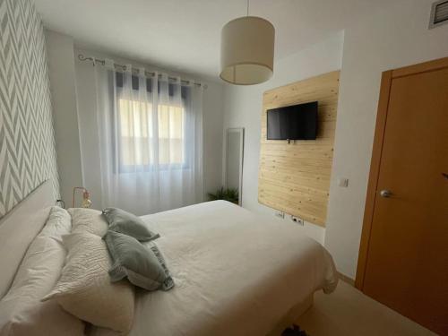 um quarto com uma cama com almofadas e uma janela em Big terrace in modern apartment close to the beach em Oropesa del Mar