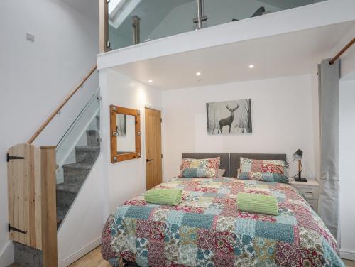 a bedroom with a bed and a staircase at Ty Den in Caernarfon