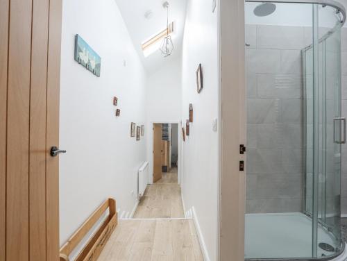 a hallway with a shower and a glass door at Ty Den in Caernarfon