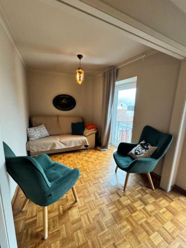 a living room with two chairs and a couch at Casas Sebastião - Tourist House in Caminha