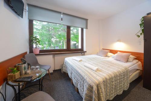 Habitación de hotel con cama y ventana en Willa Jawor, en Karpacz