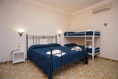 una camera con 2 letti a castello con lenzuola blu di Hotel Bolivar a Marina di Camerota