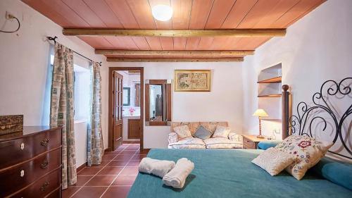 una camera da letto con un letto e un divano in una stanza di El Membrillo casa rural ad Arcos de la Frontera