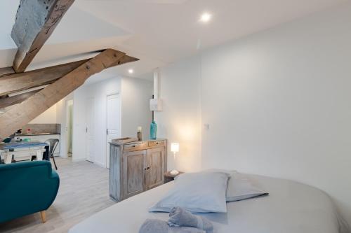 een slaapkamer met een wit bed en een blauwe stoel bij D'am Chic Nomade Appartement bleu in Périgueux
