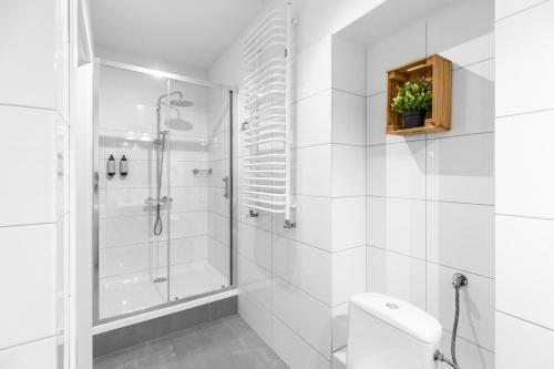 een witte badkamer met een douche en een toilet bij Amazing Apartment in the Heart of City Center - DELUX in Lublin