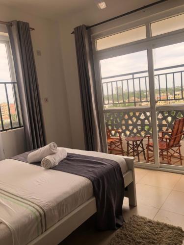 ein Schlafzimmer mit einem Bett und einem großen Fenster in der Unterkunft Leisure apartment in Mombasa